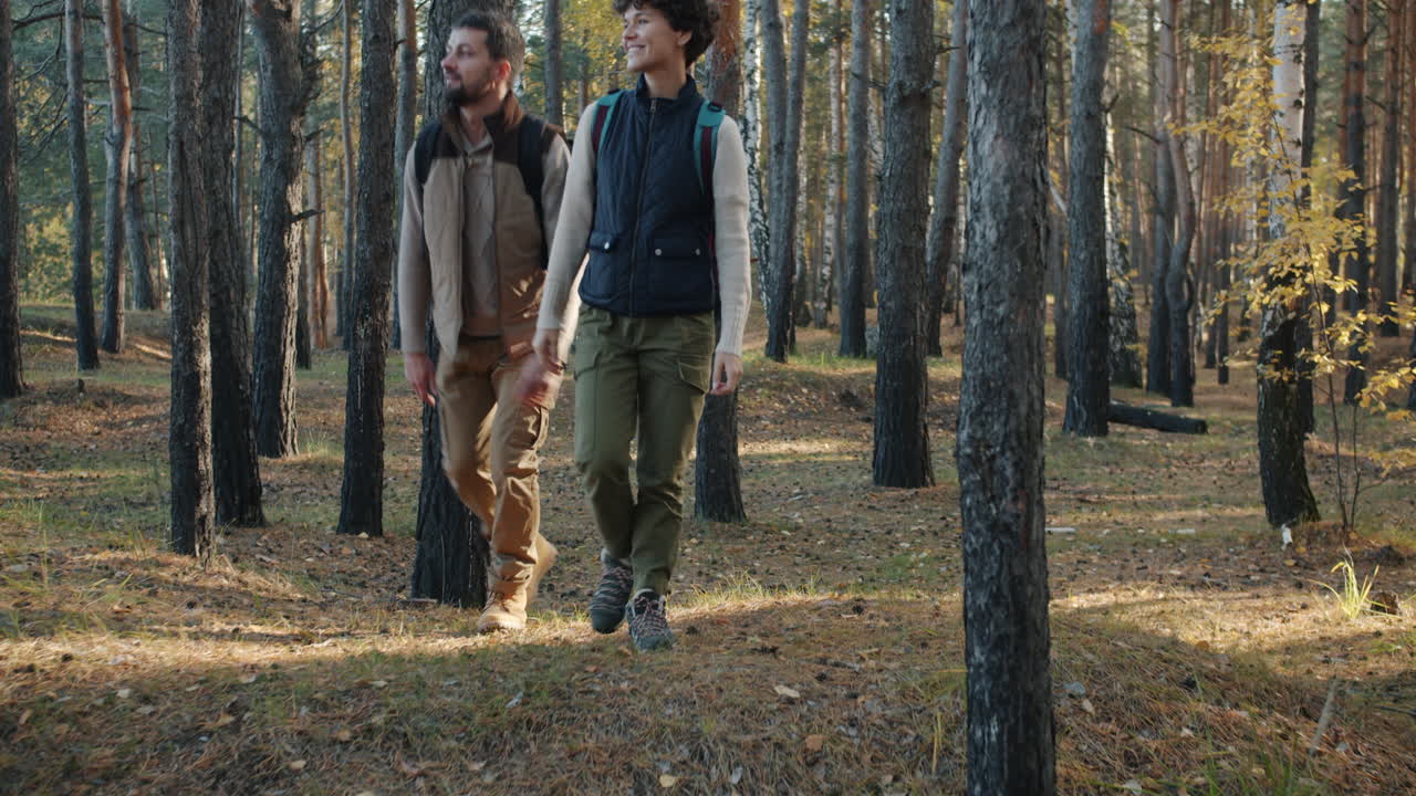 Father and daughter hiking in the forest in autumn