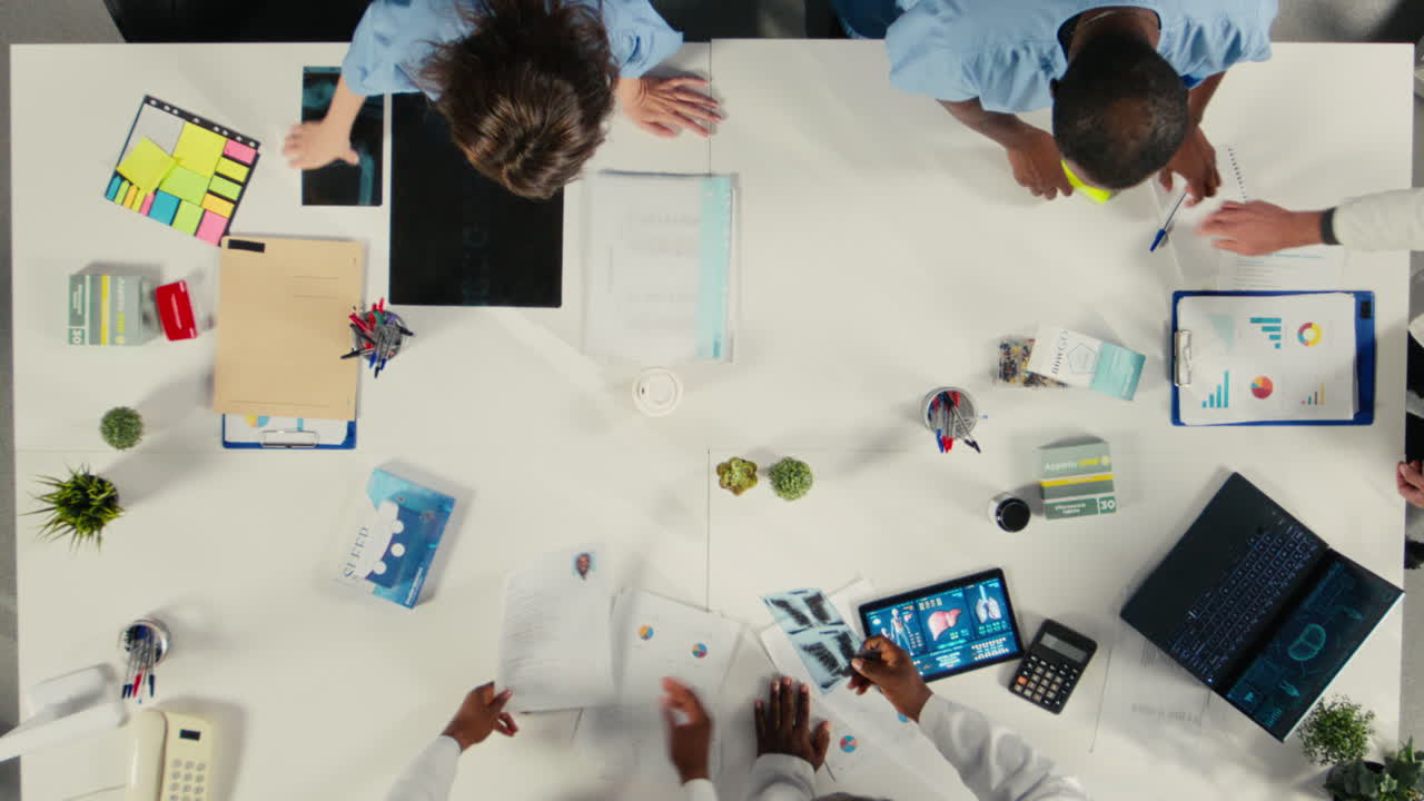 Video verticale Vista dall'alto con zoom indietro di diversi professionisti che collaborano in un brainstorming
