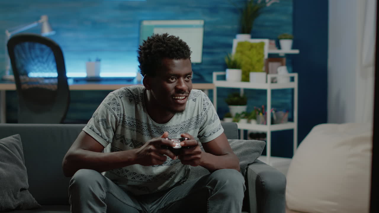 Happy man playing video games with controller on console