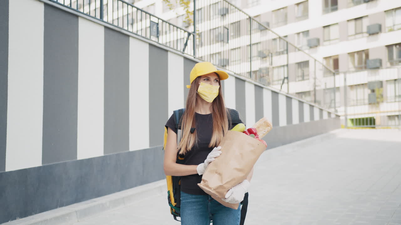 보호 장비 를 착용 하여 식료품 을 배달 하는 여자