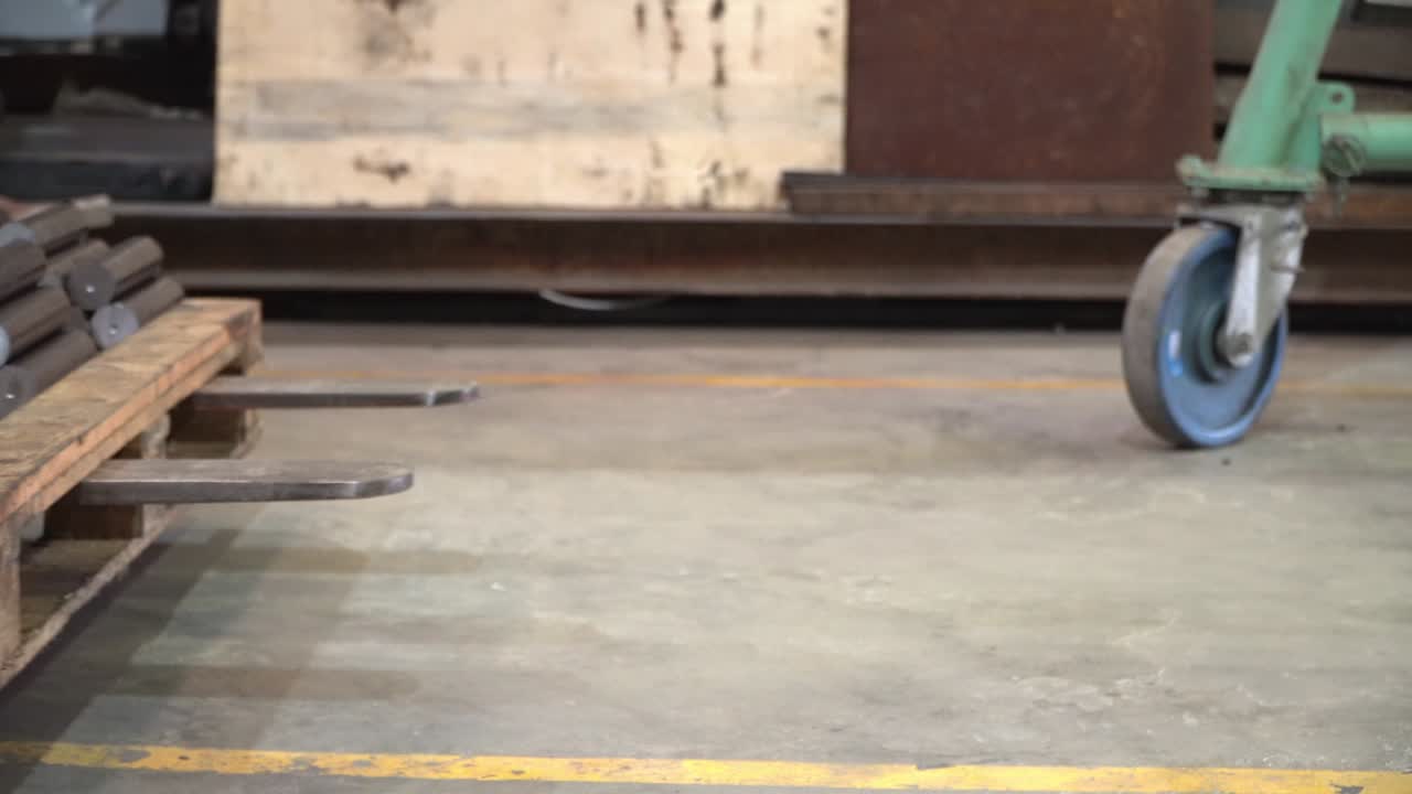 las carretillas elevadoras que mueven ejes redondos de acero para la producción industrial.