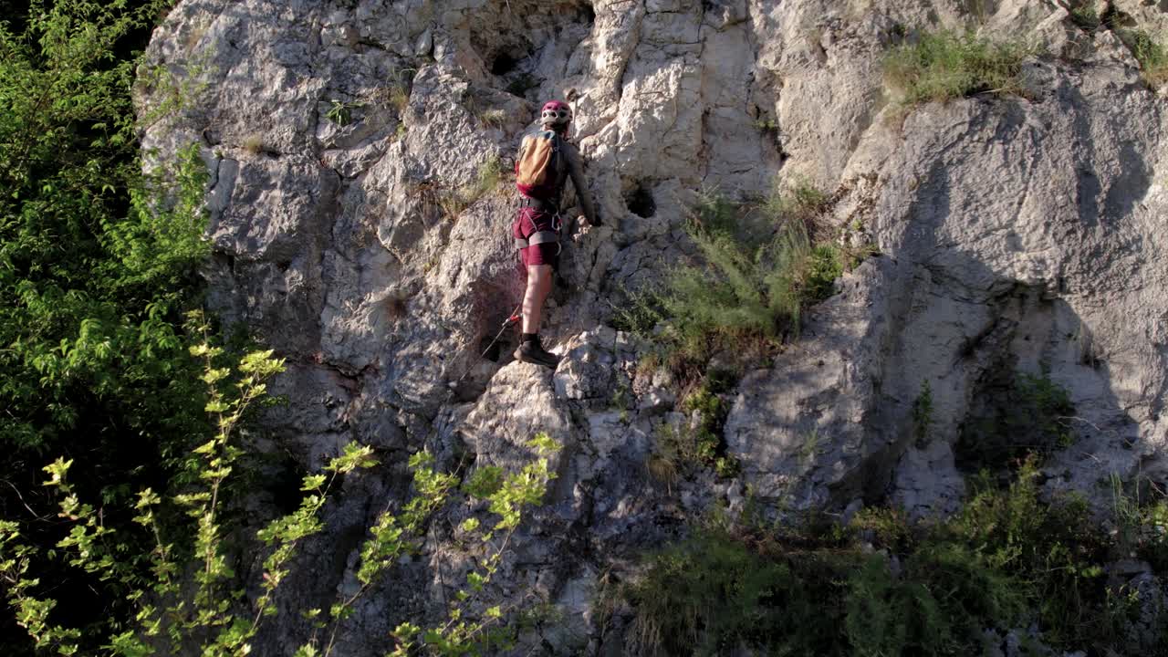 primer plano de escalada turística a través de ferrata entre el follaje de los árboles durante el verano
