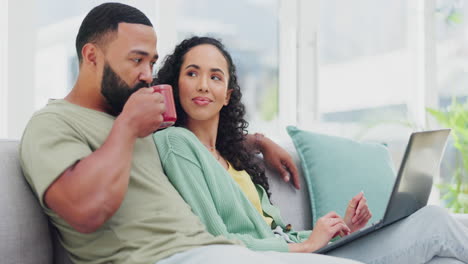 Couple,-laptop-and-talking-on-home-sofa-together