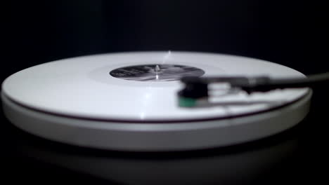 white vinyl spinning on turntable with defocused view of tone arm