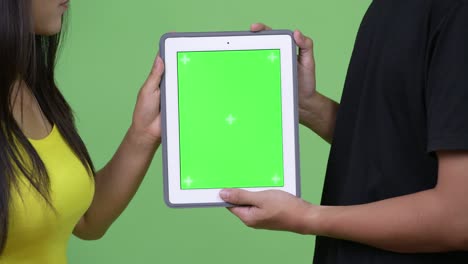 una joven pareja asiática usando una tableta digital juntos