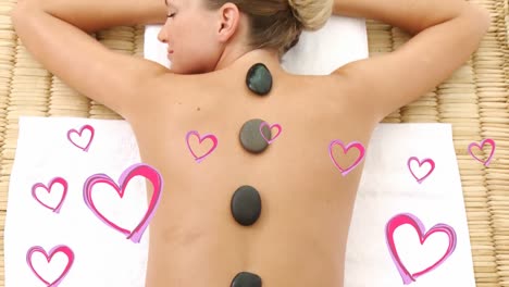 beautiful blonde women lying and relaxing at spa with pink hearts for valentine day