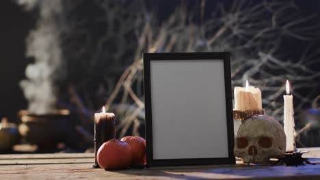 Video-of-frame-wth-copy-space,-spider-web,-skull-and-candles-on-black-background