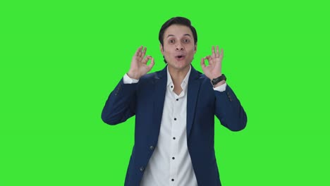 Happy-Indian-businessman-showing-okay-sign-Green-screen