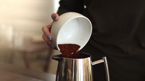 woman pouring coffee grounds