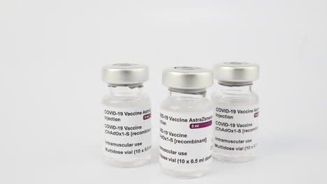 three covid-19 vaccine vials on white background, medium to close up zoom. vials to inject medical professionals and people at risk. sars-cov-2 vaccination treatment to cure infection. medical concept