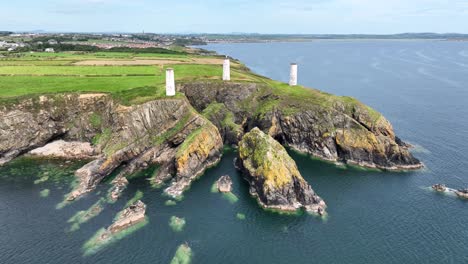 ireland epic locations aerial landscape of drone flying to the metal man towers on a headland in tramore waterford warning of the danger of tramore bay to shipping
