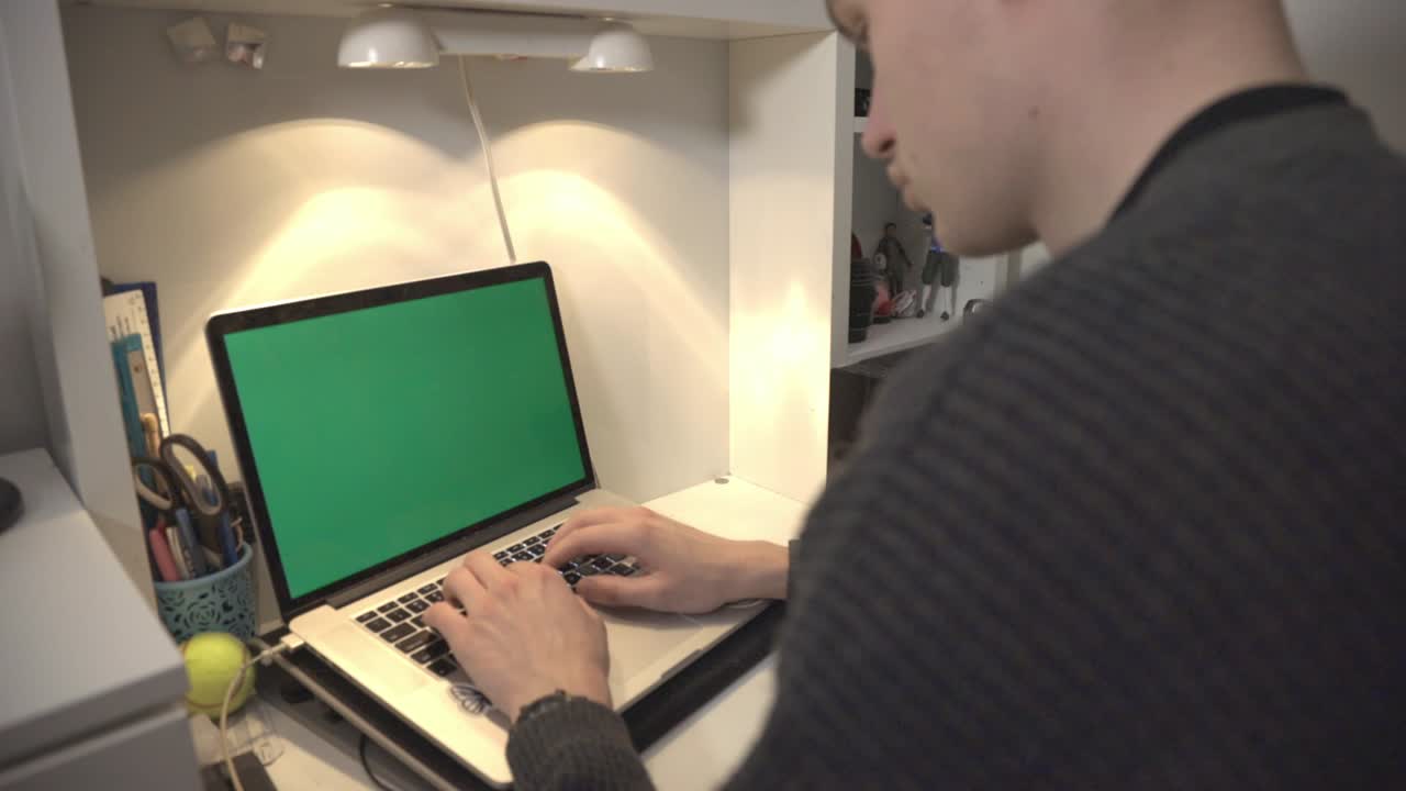 Young Man Is Typing On The Keyboard Of Laptop With Green Screen.- closeup shot