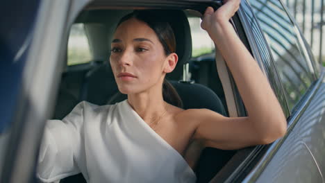 successful lady sitting car wheel close up. chic woman posing inside automobile.