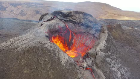 Vista-Aérea-De-Drones-Del-Cráter-Del-Volcán-Activo-Volcán-Fagradalsfjall-Con-Rocas-De-Lava-Cayendo-En-Islandia