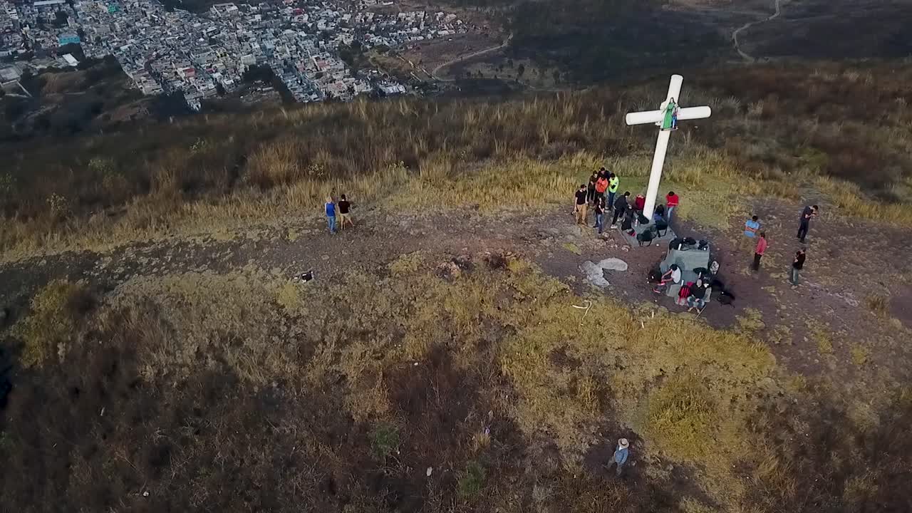 Aerial View of People Gathered Around a Cross on a Hilltop