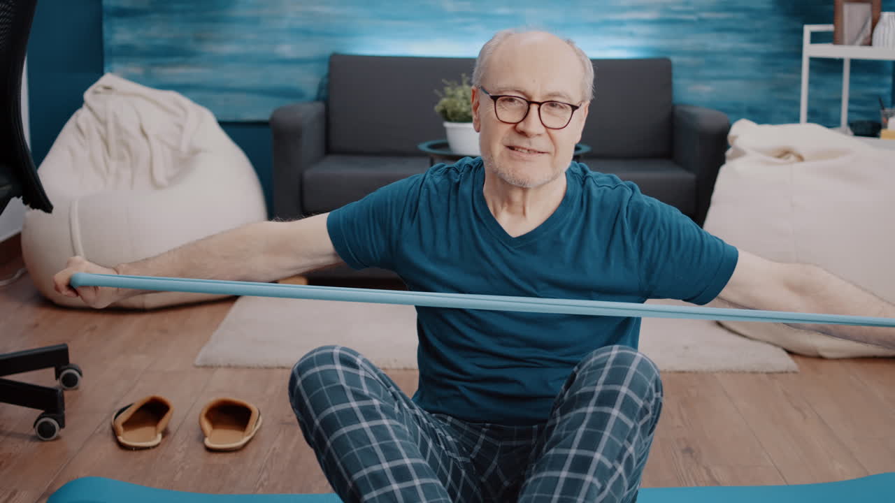 Close up of aged person using resistance band to stretch