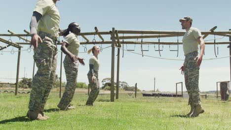 fit diverse group of soldiers doing jumping jacks on army obstacle course in the sun