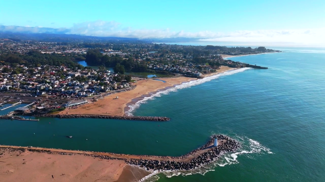 SeaBright Blacks Beach Walton Lighthouse Monterey Bay Santa Cruz Kalifornien Luftaufnahme Drohne malerische Landschaft tiefblau Brandungswellen Sand Pazifischer Ozean Pleasure Point morgendlicher blauer Himmel Nebel rückwärts.