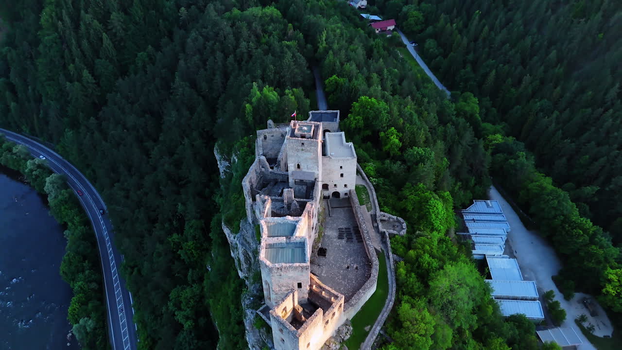 Flying over the old castle situated on the dangerous rock. Amazing verdant mountains on Slovakia wilderness around