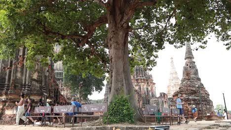 tourists exploring historical temple ruins under trees