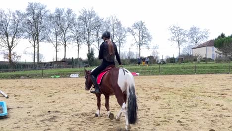 jockey femenino montando su pony en el paddock