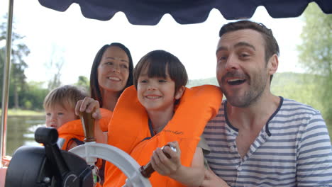 family enjoying day out in boat on river shot in slow motion