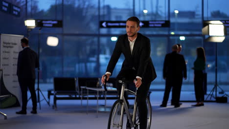 businessman in a suit riding a bicycle indoors