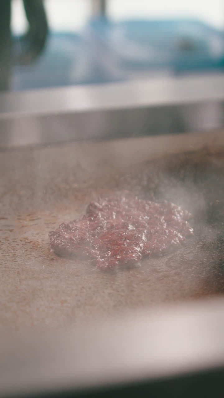 Burger patties grilling on a flat-top grill
