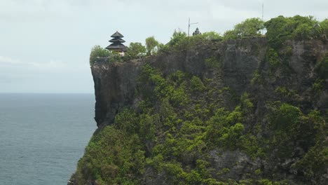 slow-motion long shot of a temple on a cliff in uluwatu, bali