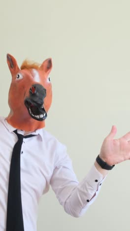 crazy young man in a horse mask dancing rhythmically on a white background crazy young man in a horse mask dancing rhythmically on a white background slow motion the holiday of happiness horse face positive emotions