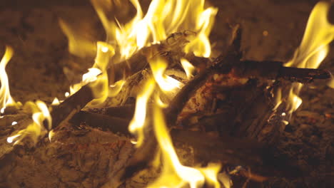 Panning-motion-shot-of-sticks-burning-in-a-fire-pit