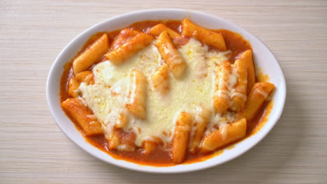 pastel de arroz coreano en salsa coreana picante con queso, tokpokki de queso, tteokbokki con queso - estilo de comida coreana