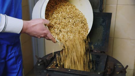 Worker-pours-wood-shavings-1