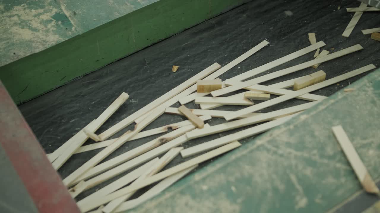Small Wooden Strips Moving on an Industrial Conveyor Belt