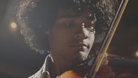 young african american violin player performing on stage
