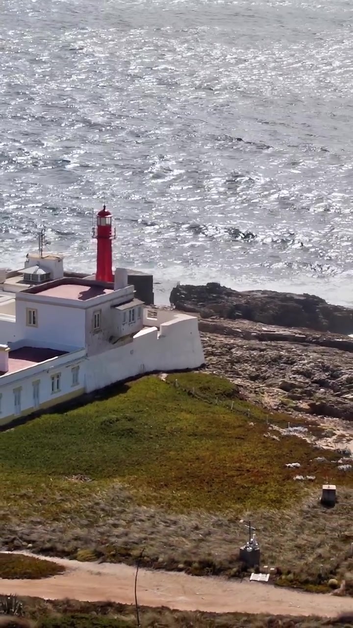 Vista aerea del faro vicino alla costa in Portogallo con onde oceaniche