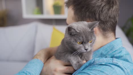 Man-hugging-his-gray-pet-cat.