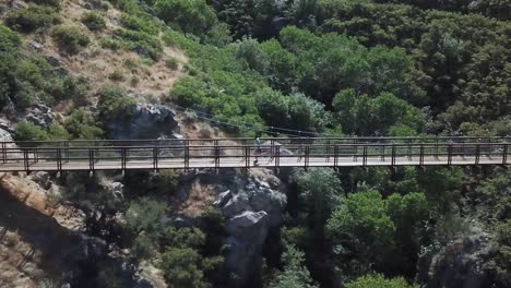 Disparo-De-Un-Dron-Siguiendo-A-Un-Hombre-Activo-Corriendo-En-Un-Puente-Colgante-Colgante-Al-Aire-Libre-Sobre-El-Cañón-Del-Oso-En-Draper-City,-Utah-1