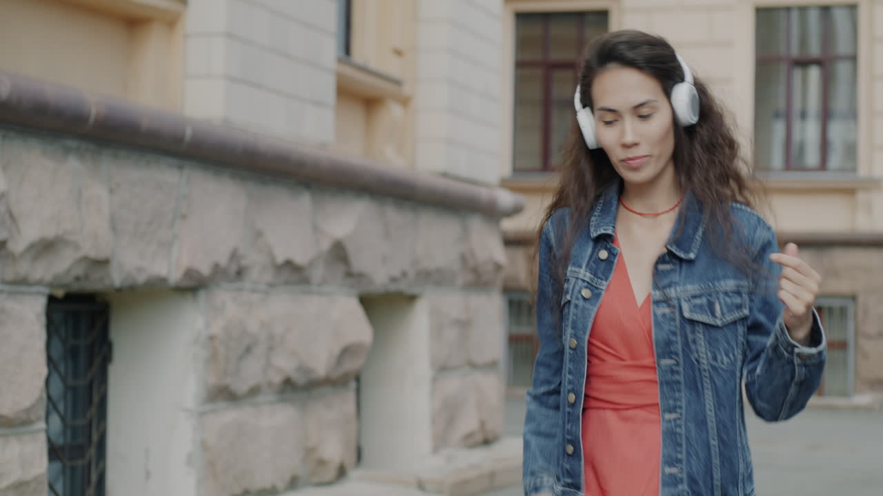 Woman Dancing with Headphones in the City