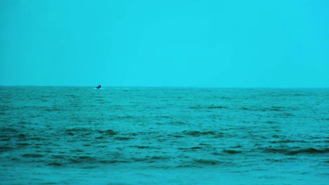 Vista-Lejana-De-Un-Hombre-Montando-Moto-Acuática-Sobre-Agua-De-Mar-Azul-En-El-Océano-Índico