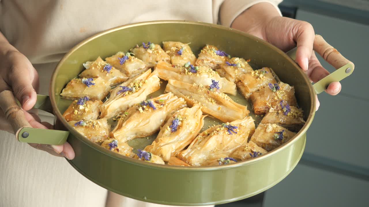 mujer sosteniendo una bandeja de baklava