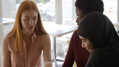 young adult female friends hanging out in a cafe