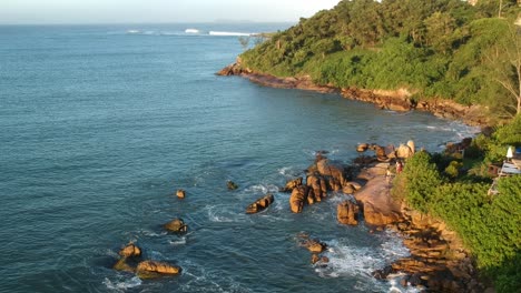 am nachmittag über einen strand in brasilien fliegen, nahe der felsigen küste