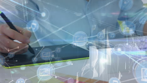 animation of network of digital icons over mid section of male graphic designer using graphic tablet