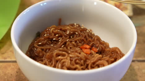 Sesamsamen-Auf-Eine-Schüssel-Ramen-Nudeln-Streuen