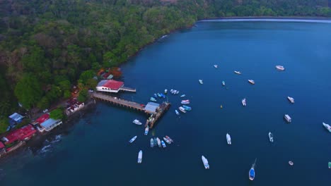 Drone-looking-down-on-sailboats-and-yachts-in-the-calm-bay-water-of-Ballena-Bay-in-Costa-Rica-during-dusk-on-a-summer-night