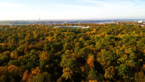 Toma-De-Drones-De-Un-Estadio-De-Darius-Y-Girenas-En-Un-Parque-De-Madera-De-Roble-Con-árboles-De-Colores-Vibrantes-En-Un-Día-Soleado-En-La-Ciudad-De-Kaunas-En-Lituania-En-Otoño,-Tiempo-De-Otoño