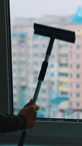 worker washing plastic window. man cleaning window with a brush inside the high building in the city. washing glass window. vertical video