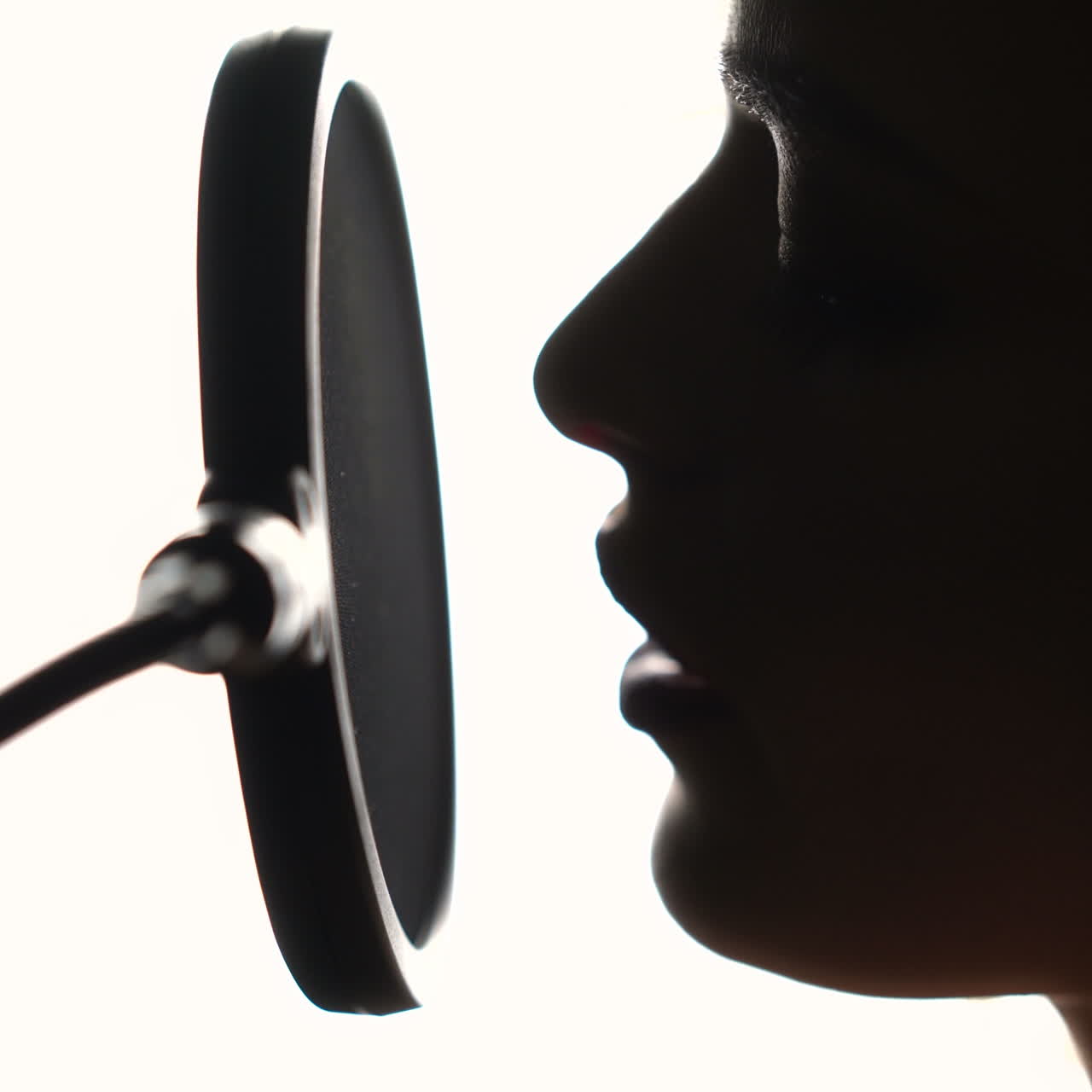 Beautiful young singer who recorded a song in a professional recording studio. Close-up face. Square video