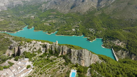 aerial view of a mountainous region with a turquoise lake and village
